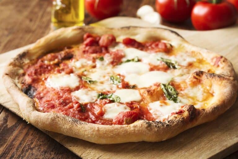 Pizza margherita chaude sur planche en bois.
