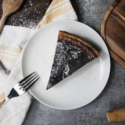 Part de tarte au chocolat sur assiette blanche.