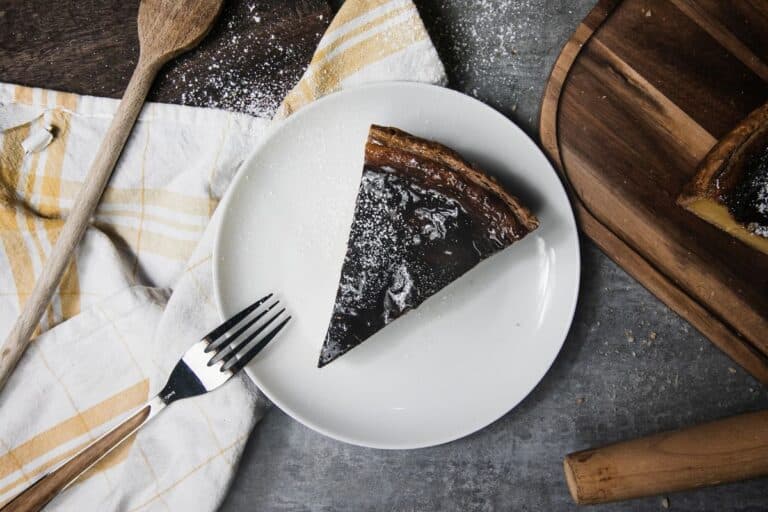 Part de tarte au chocolat sur assiette blanche.