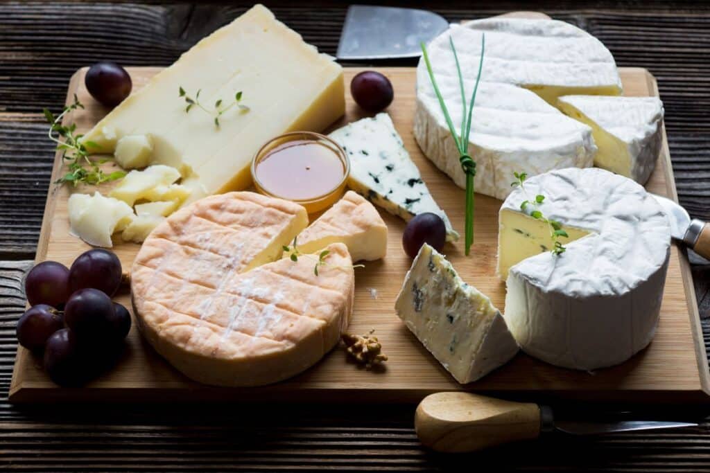 Plateau de fromages variés avec raisins et noix.