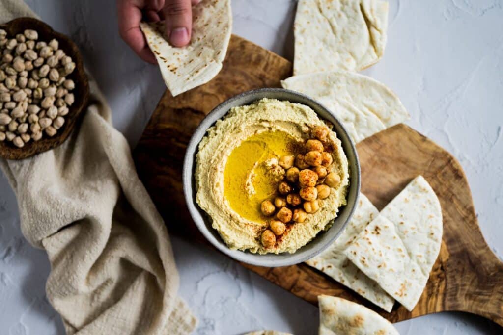 Bols de houmous avec pain pita et pois chiches.