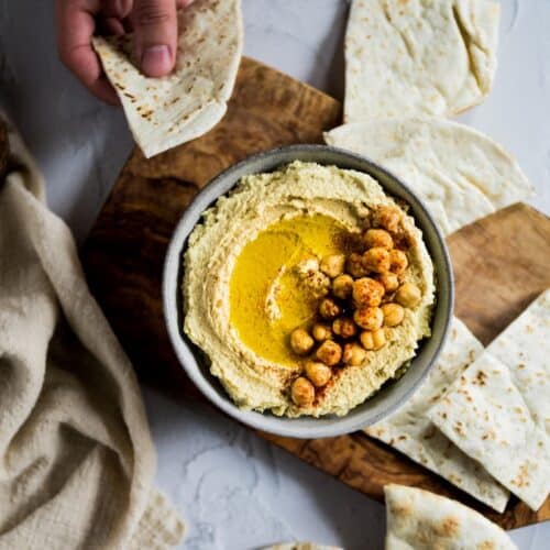 Bols de houmous avec pain pita et pois chiches.