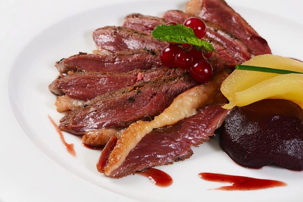 Magret de canard sauce fruits rouges, poire pochée.