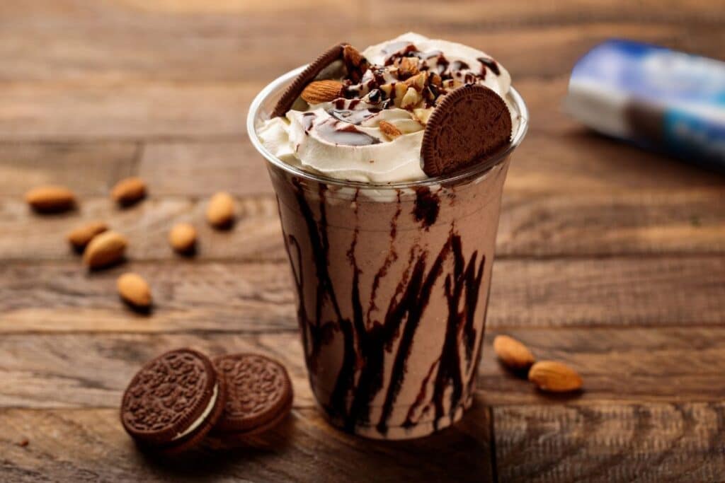 Milkshake chocolat et biscuits, amandes en arrière-plan.