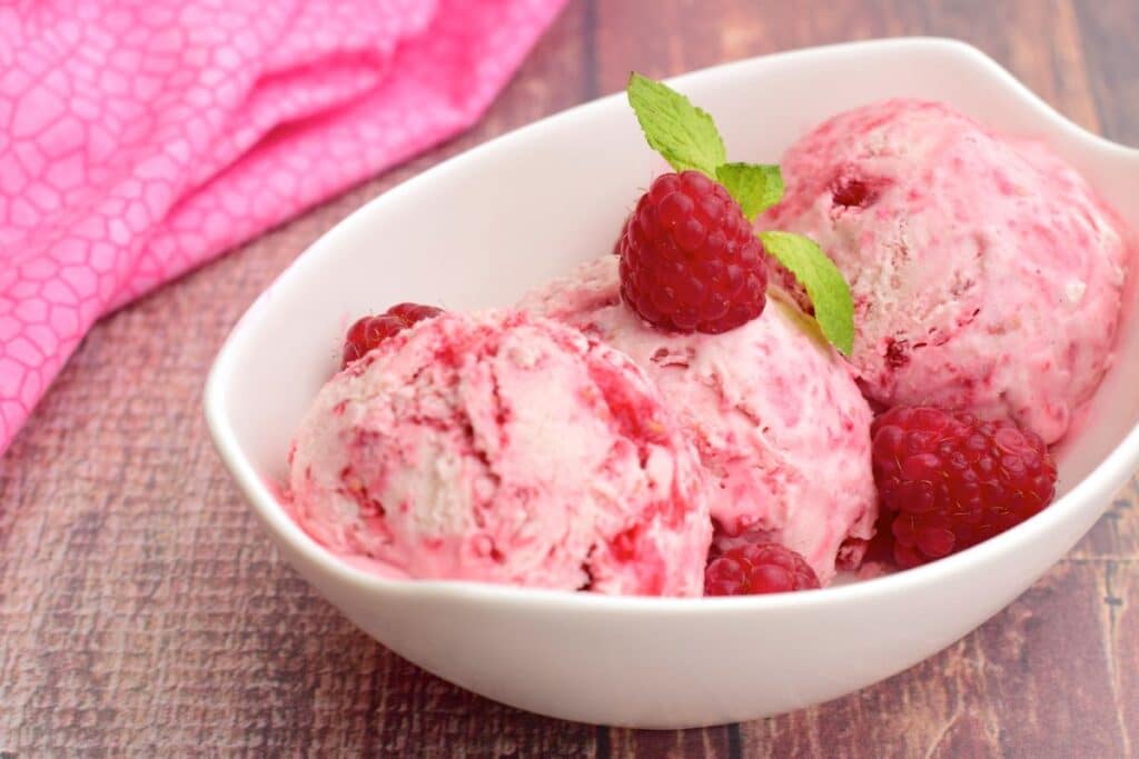Glace framboise dans une coupe blanche.