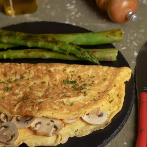 Omelette aux champignons et asperges sur une assiette.