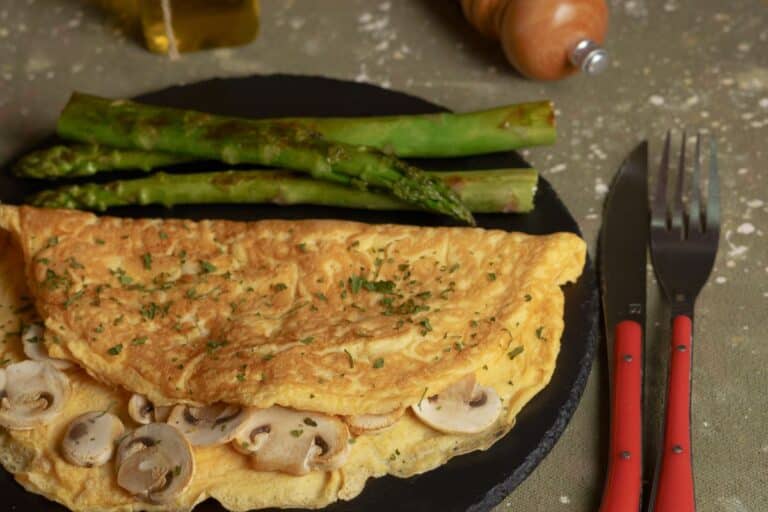 Omelette aux champignons et asperges sur une assiette.