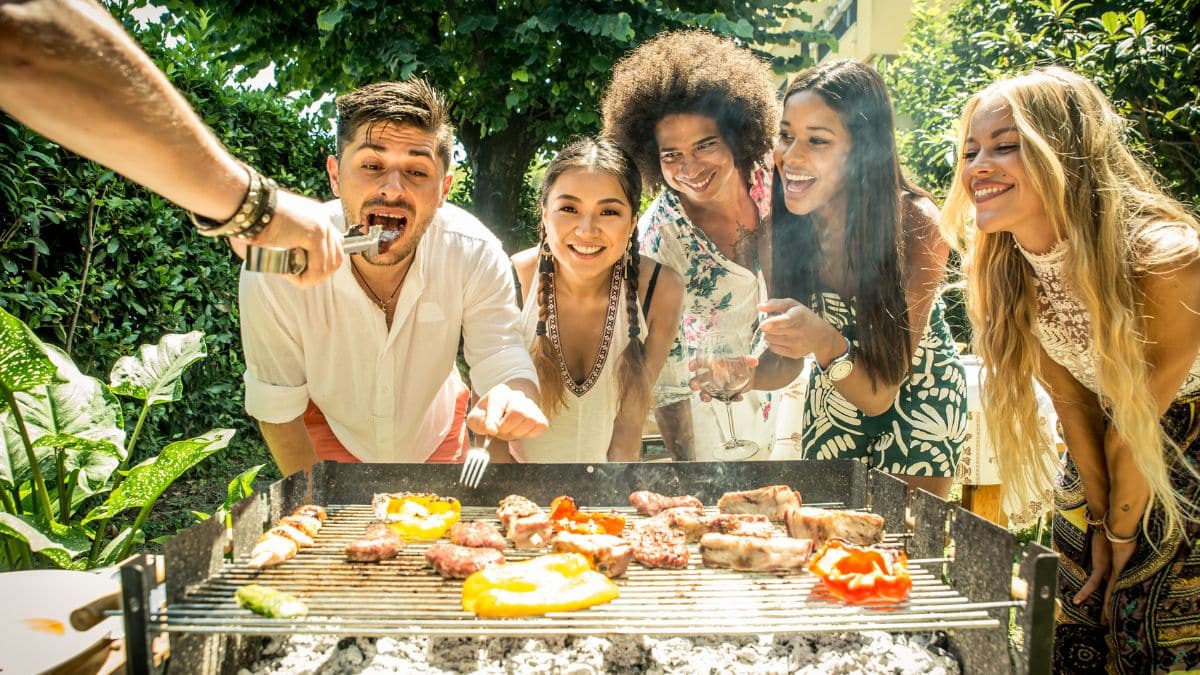 Groupe d'amis profitant d'un barbecue en extérieur.