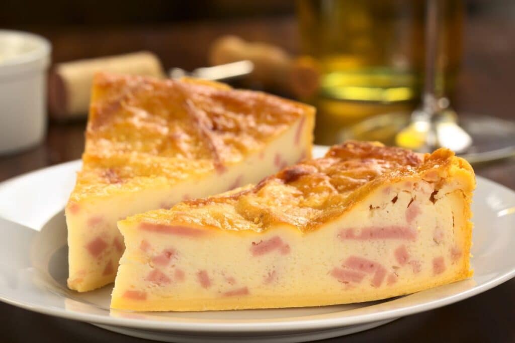 Deux parts de quiche lorraine sur une assiette blanche.