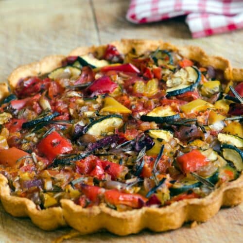 Tarte aux légumes colorés sur une planche.