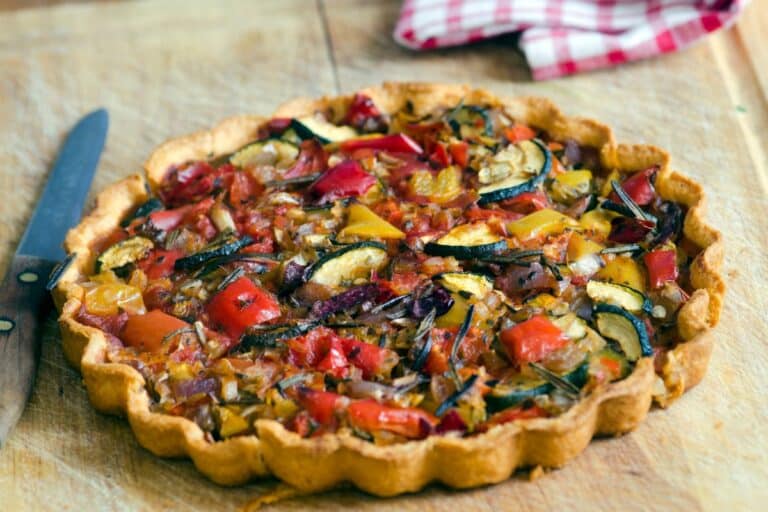 Tarte aux légumes colorés sur une planche.