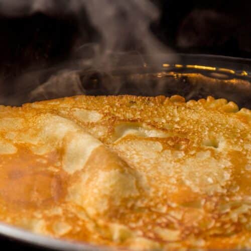 Crêpe chaude dans une poêle, vapeur visible.