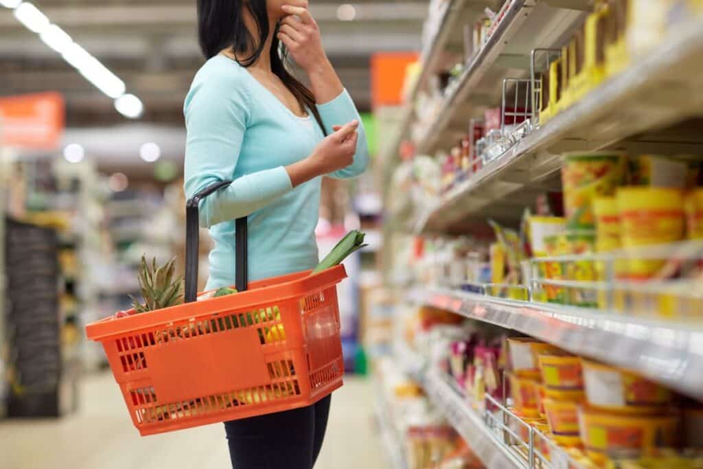 Personne choisissant produits dans un supermarché.