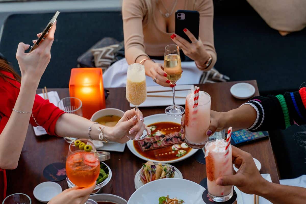 Personnes trinquant avec divers cocktails dans un restaurant.