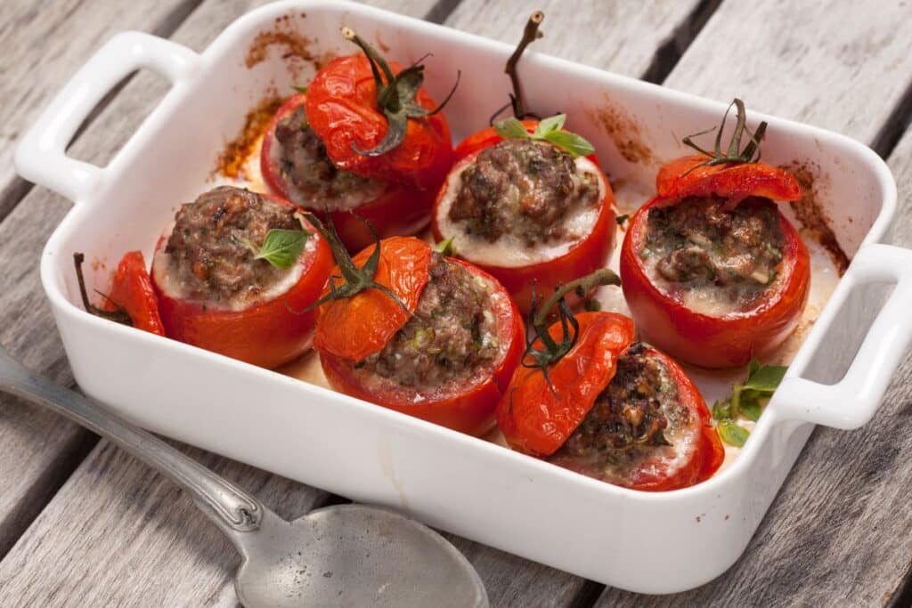 Tomates farcies au four dans un plat blanc.