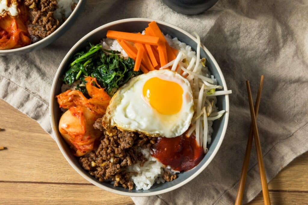 Bol de bibimbap coréen avec œuf, légumes et riz.