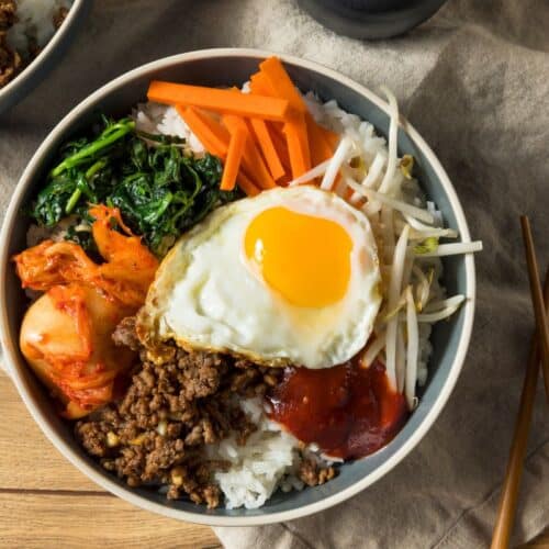 Bol de bibimbap coréen avec œuf, légumes et riz.