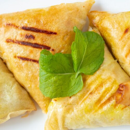 Samoussas frits avec garniture de menthe fraîche.