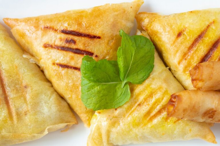 Samoussas frits avec garniture de menthe fraîche.