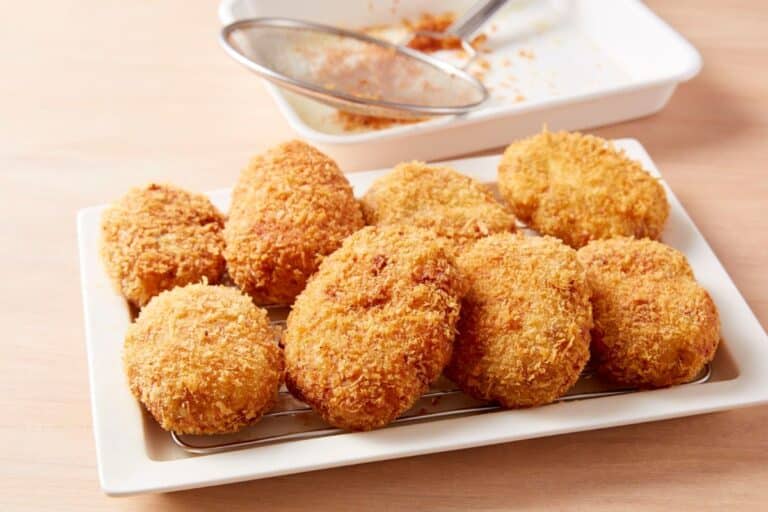 Croquettes dorées et croustillantes sur une assiette blanche.