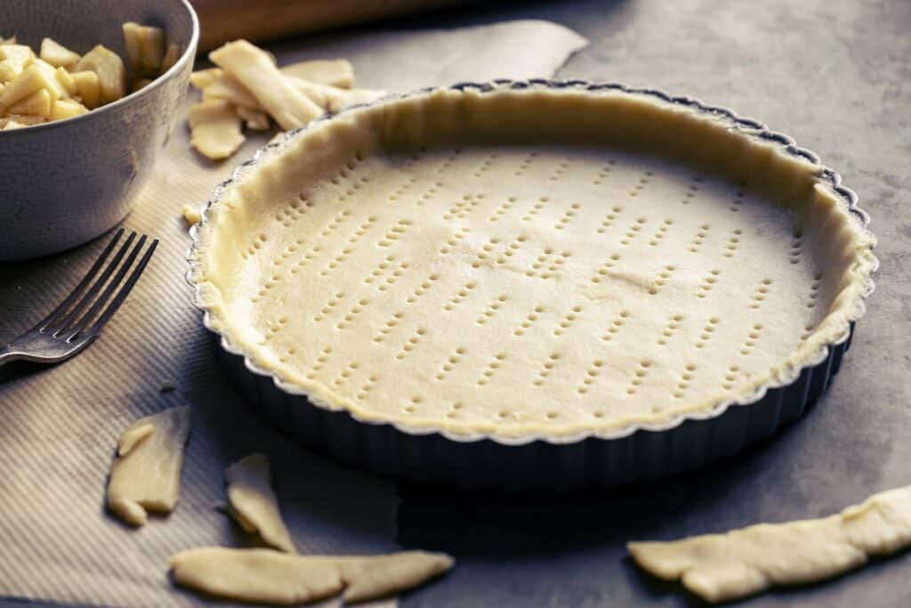Pâte brisée crue dans un moule à tarte.