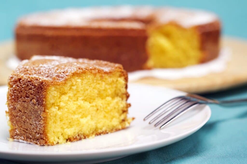 Tranche de gâteau moelleux sur assiette blanche.