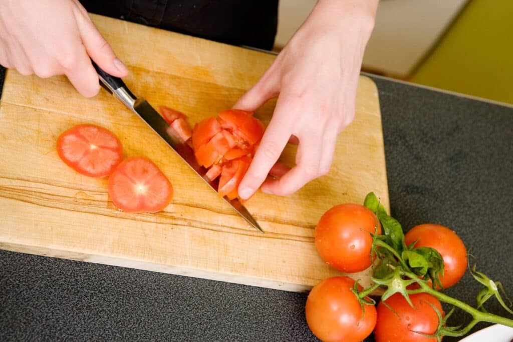 Découpe de tomates fraîches sur une planche.