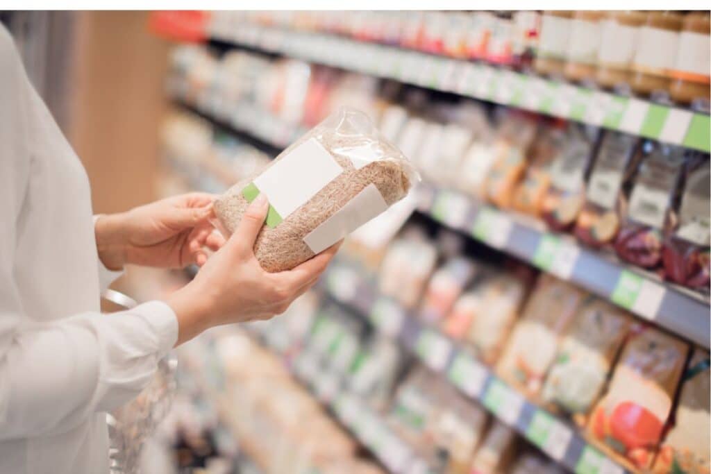 Personne tient un paquet de riz en supermarché.
