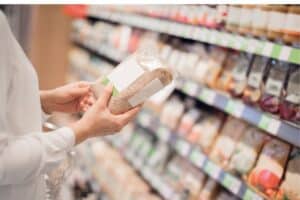 Personne tient un paquet de riz en supermarché.
