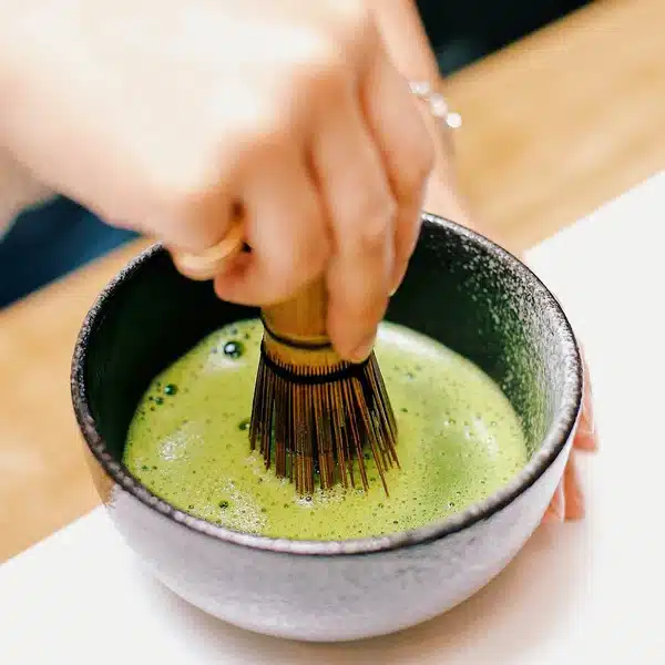 Préparation du thé matcha avec un fouet.