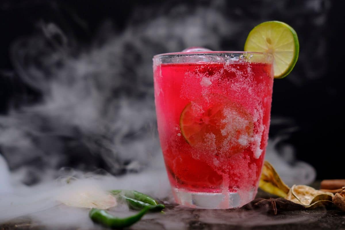 Cocktail rouge frais avec citron vert et fumée.
