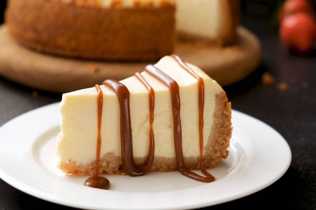 Cheesecake avec caramel en filet sur assiette.