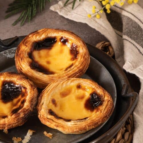 Trois pastéis de nata sur une assiette.