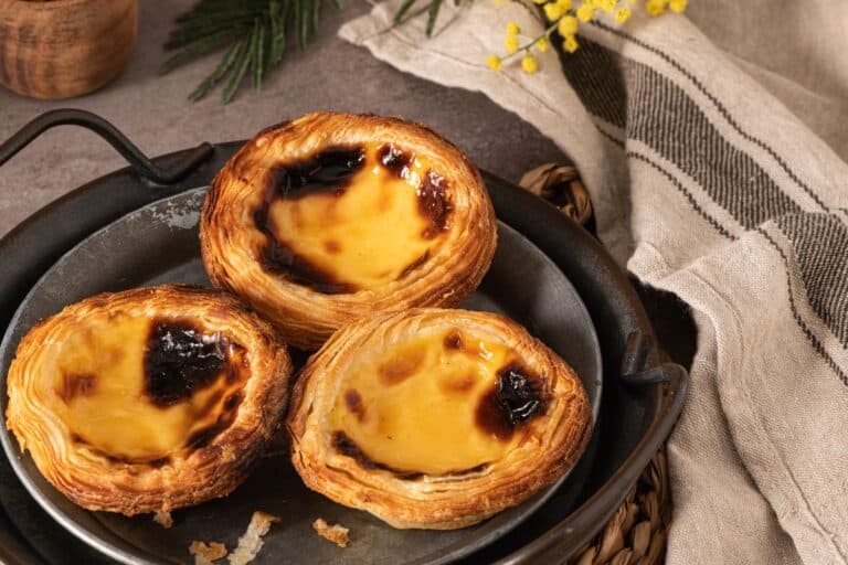 Trois pastéis de nata sur une assiette.