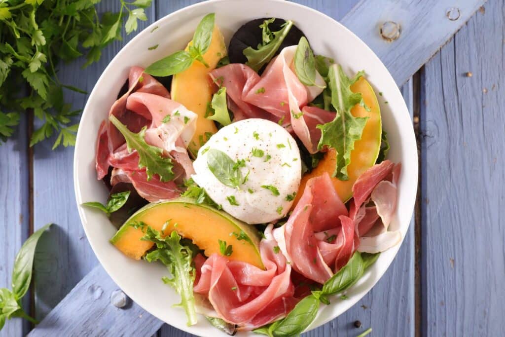 Salade fraîche avec mozzarella, jambon et melon.