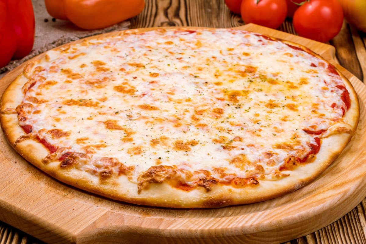 Pizza margherita sur planche en bois.
