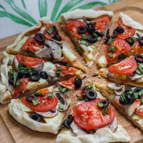 Pizza aux légumes frais sur planche bois.