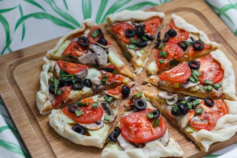 Pizza aux légumes frais sur planche bois.