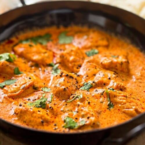 Poulet au curry dans une poêle noire.