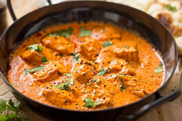 Poulet au curry dans une poêle noire.