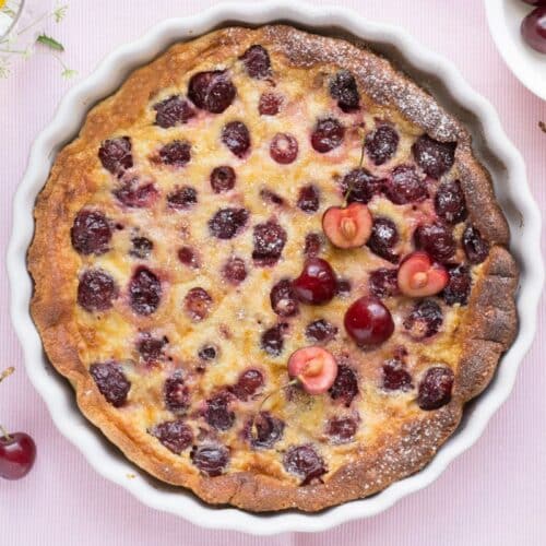 Clafoutis aux cerises dans un plat blanc.