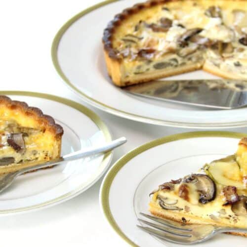 Tarte aux champignons sur assiettes blanches.