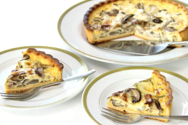 Tarte aux champignons sur assiettes blanches.