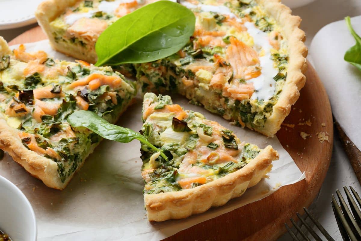 Quiche saumon épinards sur planche bois.
