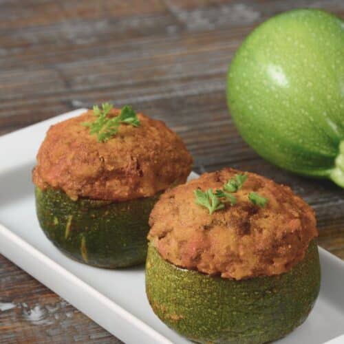 Courgettes rondes farcies sur assiette blanche.