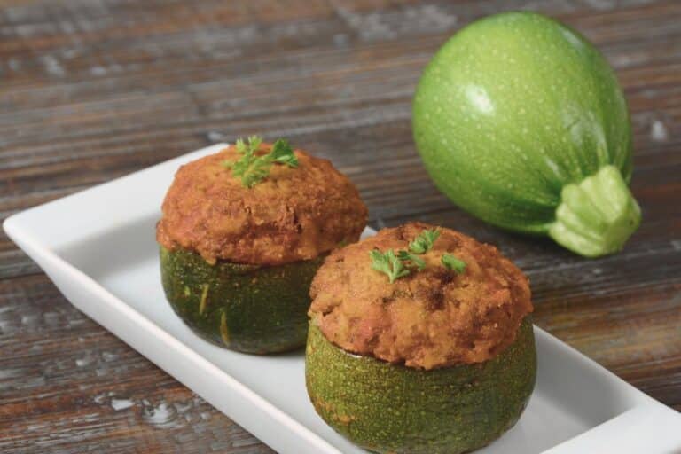 Courgettes rondes farcies sur assiette blanche.