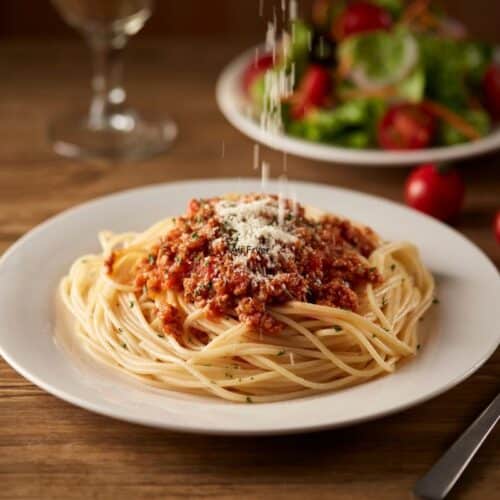 Assiette de spaghetti bolognaise avec parmesan.