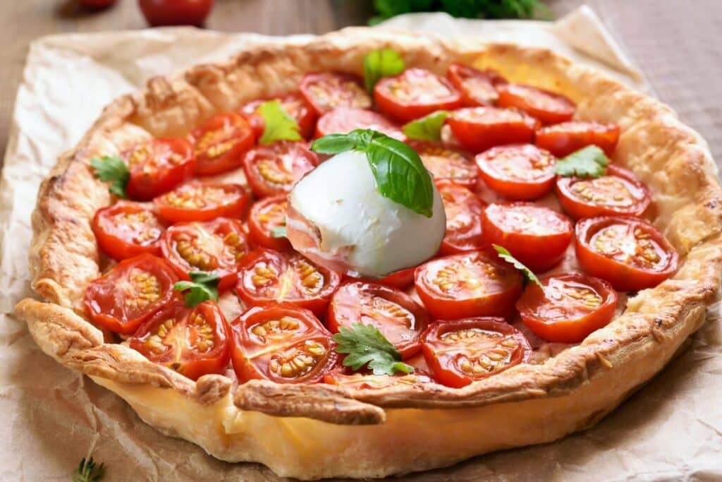 Tarte tomate mozzarella basilic sur une pâte dorée.