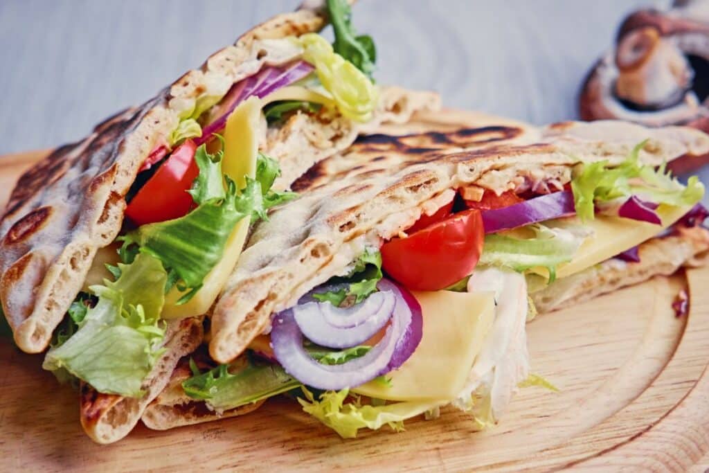 Sandwich pita garni de légumes et fromage.