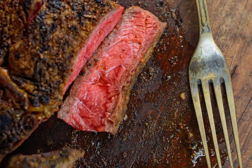 Tranche de viande saignante avec une fourchette.